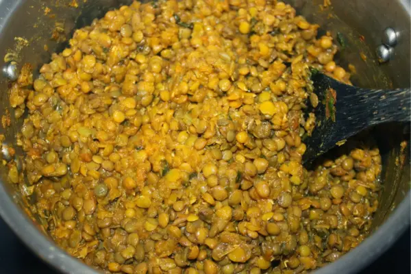 Faire revenir l’ail, les oignons et l’échalote dans une poêle huilée, puis ajouter le coulis de tomates, les épices et les lentilles.